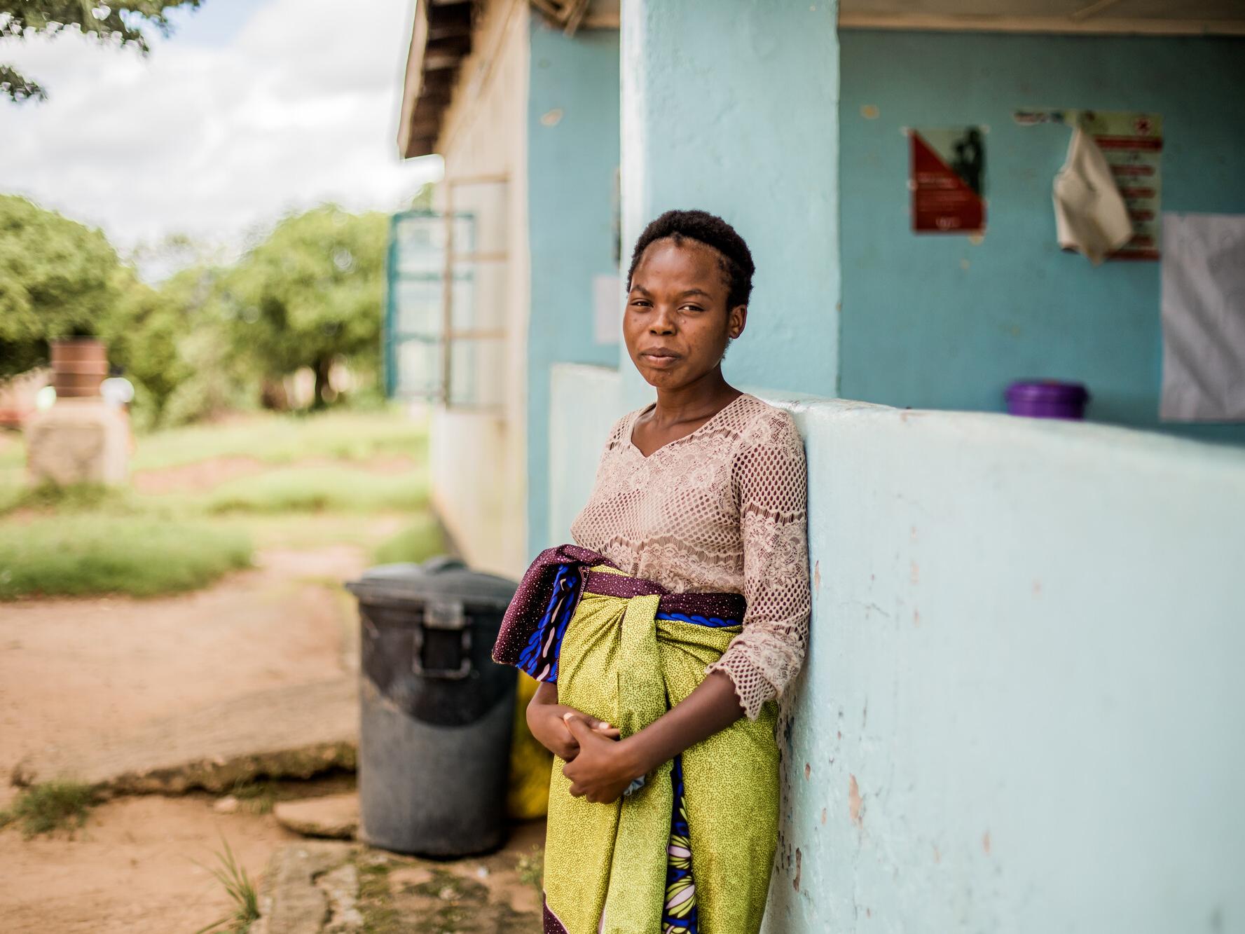 Keira, 18, standing outside her home in Zambia