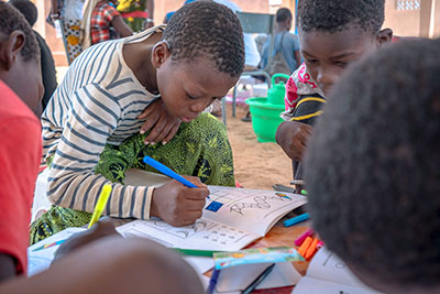 A school girl writing in her school book