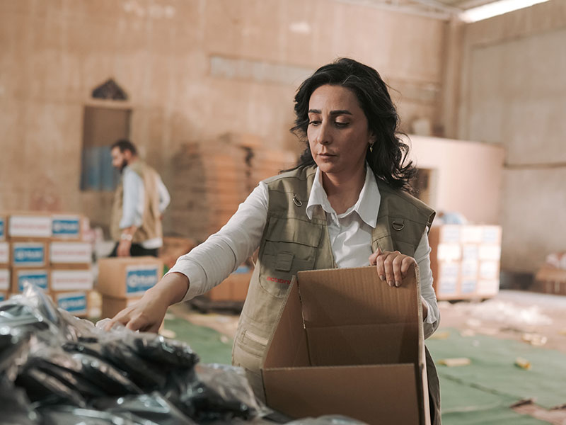 Plan International staff preparing boxes of dignity kits for women in Gaza.  