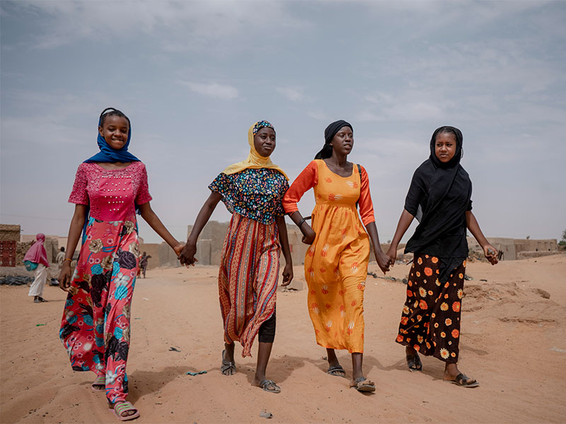 Aminata and three friends walking to school. 