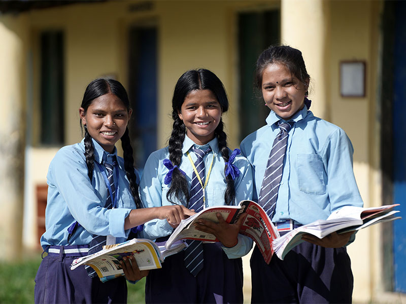 Three girls holding school books