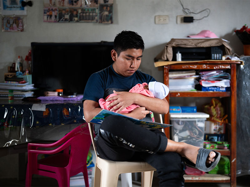 Leiver cradling baby daughter in his arms