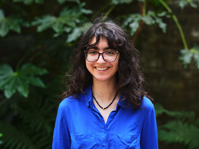 Headshot of Neylia standing outside with leaves in background