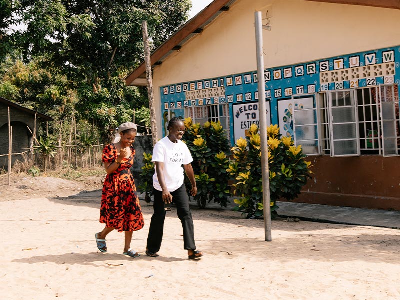 Fatmata and Mamah walk outside the adolescent-friendly centre in Sierra Leone