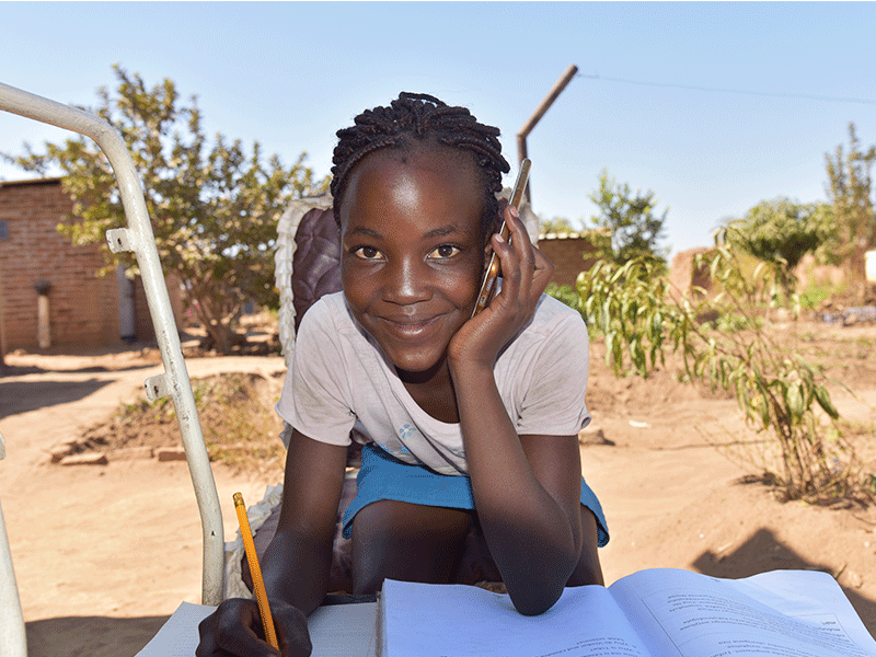 Yollanda, 12, uses her mobile phone to connect with a community educator 