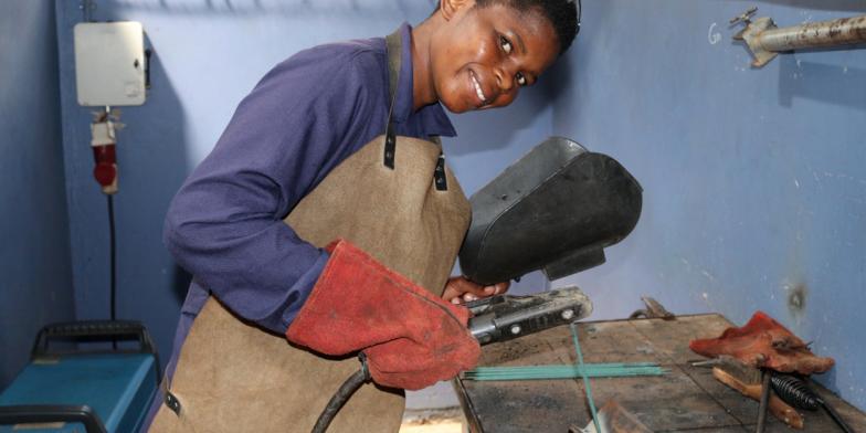 Jennifer, 20, welding with a blow torch in a workshop in Kenya
