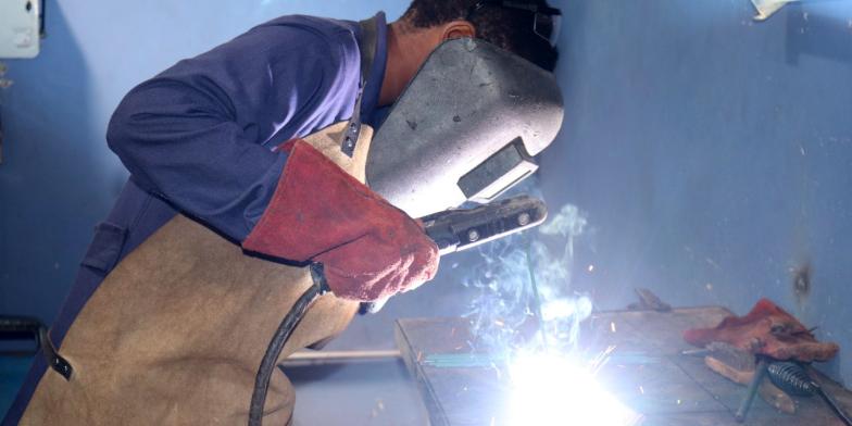 Jennifer, 20, welding with a blow torch in a workshop in Kenya