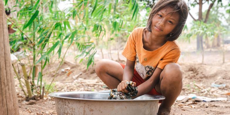Muta, 11, washes clothes at her home in Stung Treng Province  