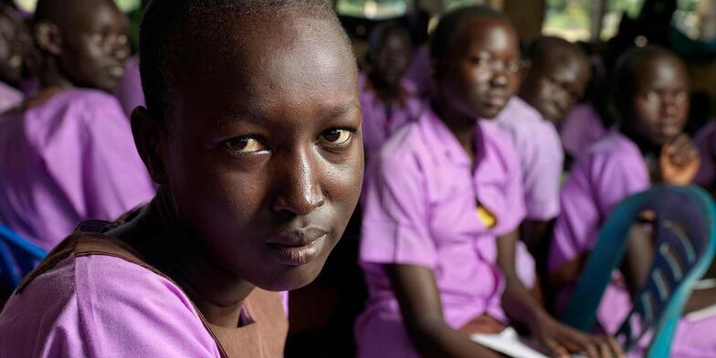 15-year-old Martha from South Sudan sitting in her school classroom with other pupils.