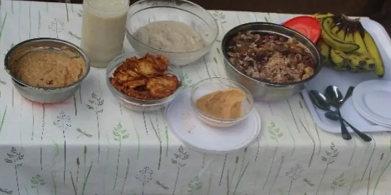 Bowls of food, plates and cutlery on table.