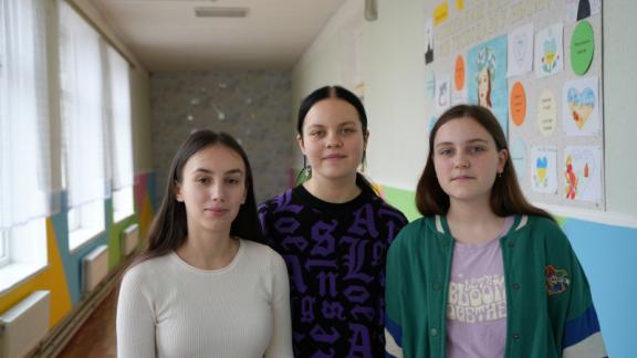 From left to right: Friends Zenhya, 17, Amina, 14, and Nastya, 15, return to a safe and refurbished school