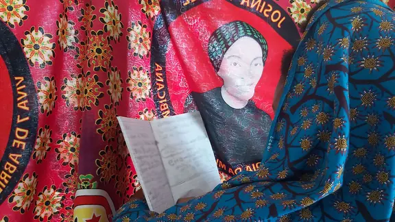 In Mozambique, Maria* reads through one of her school books.