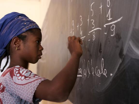 Salimata, 12, does sums on a blackboard at her primary school in Mali
