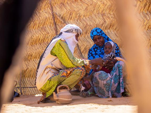 Balkissa’s baby is checked for signs of malnutrition by a health worker in Niger.