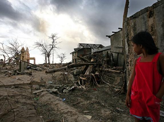 A girl looks at the devastation caused by Typhoon Haiyan in the Philippines