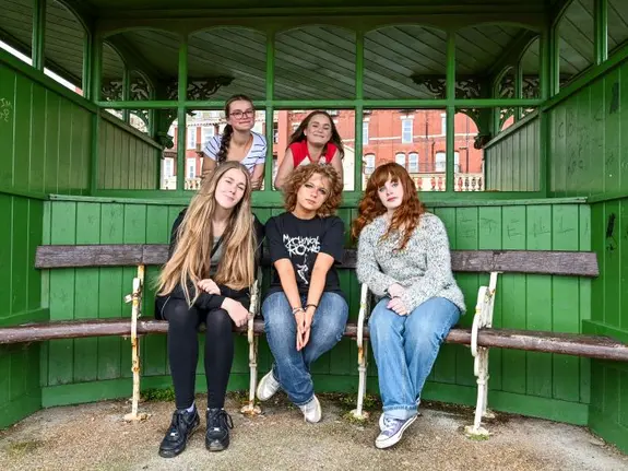 five girls smile at the camera