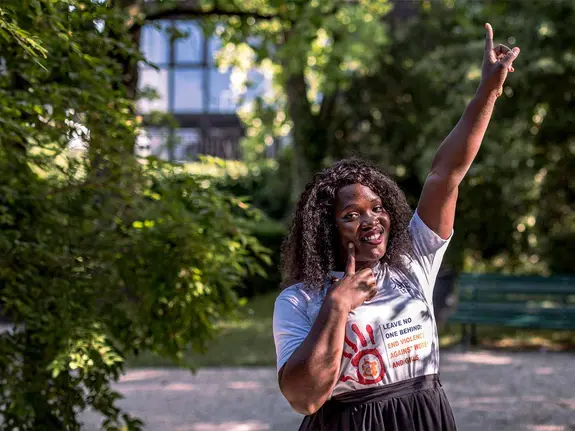 Racheal, 26, pointing her finger to the sky and smiling at the camera