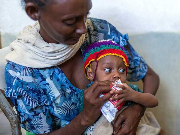 Wahid feeding her baby son some food