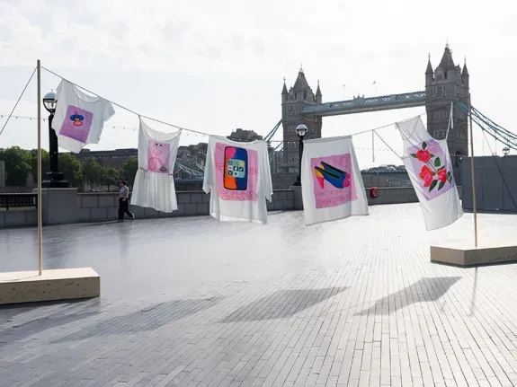 A washing line of clothes is suspended in front of Tower Bridge.