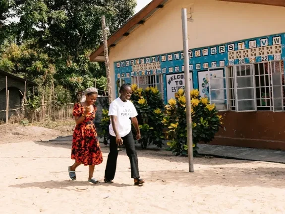Fatmata and Mamah walk outside the adolescent-friendly centre in Sierra Leone