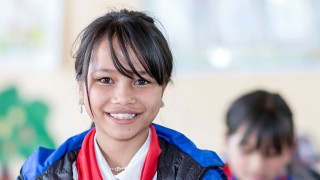 Photo of a girl in a blue jacket in a classroom
