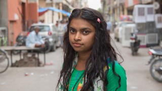 A girl stands in a street in Delhi, India