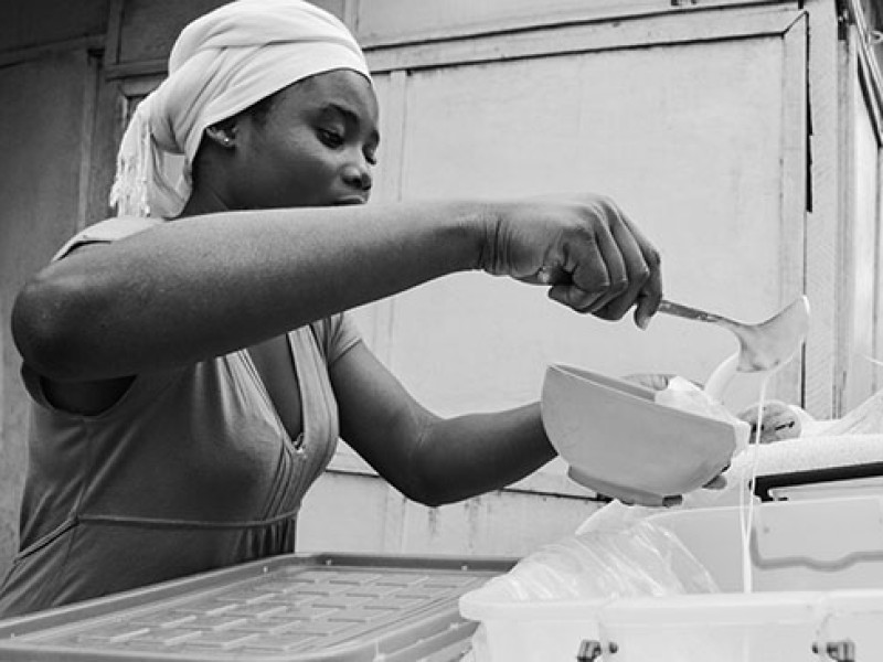 Ghana-Doris prepares an order of Burkina - she adds milk to millet and sugar