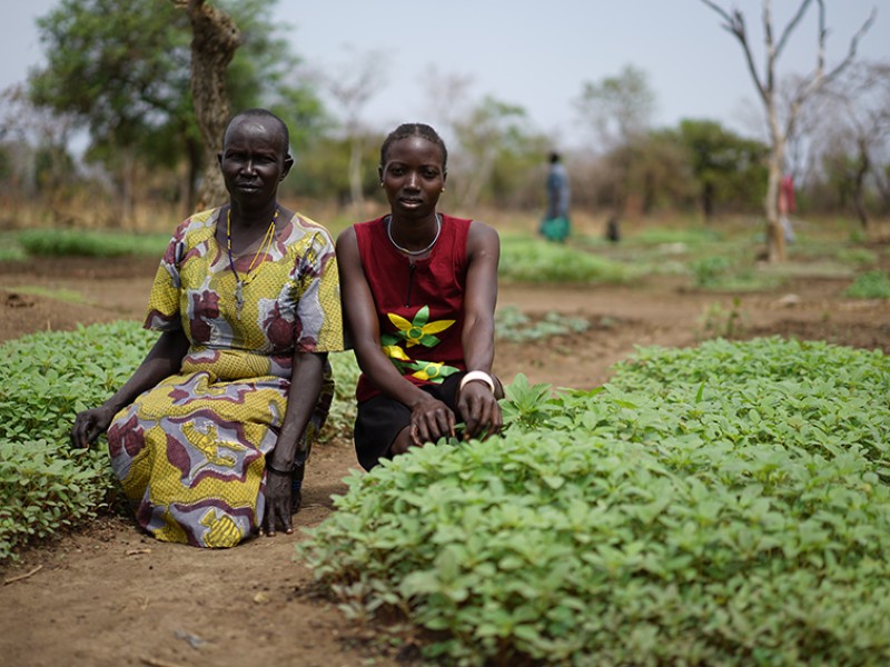 Villagers sit by their crops in South Sudan