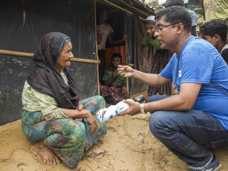 Azam, a WASH specialist, speaks with a resident in Cox’s Bazar, Bangladesh