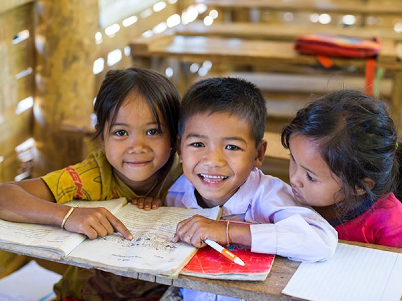 Children read books at their school in Laos