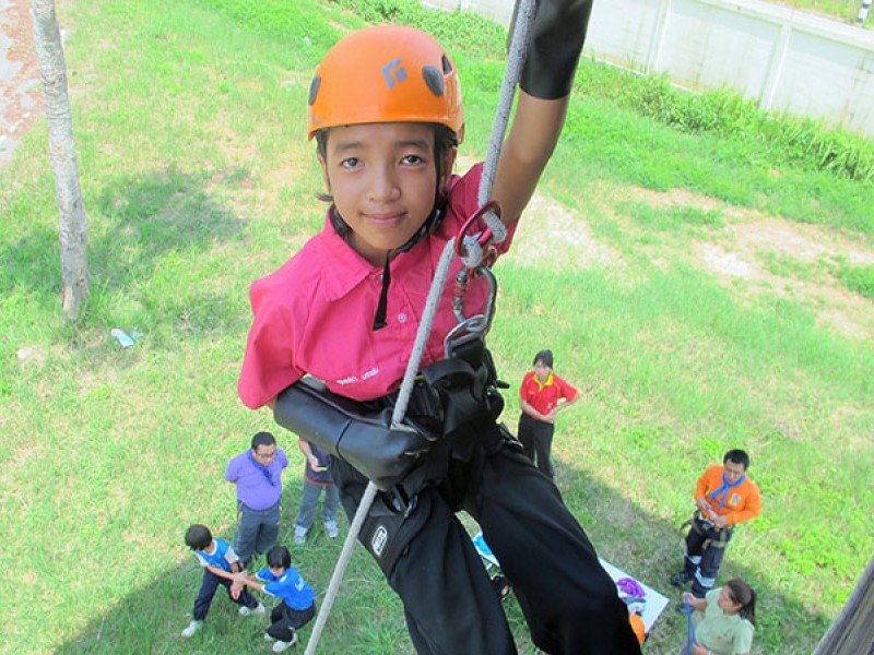 A girl learns to abseil at survival camp in Thailand