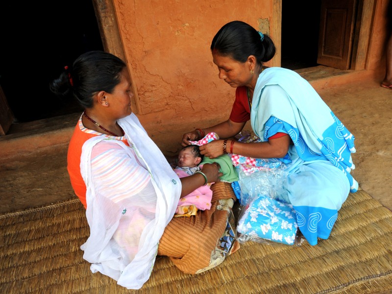 Community healthcare worker in Nepal helps a woman with a newborn baby