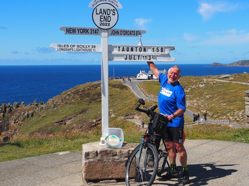 A man with a bicycle at Land's End