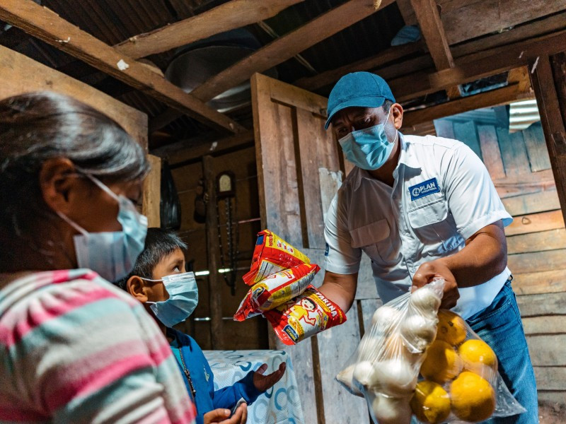 Plan International staff member Oscar handing out food to a family in Guatemala