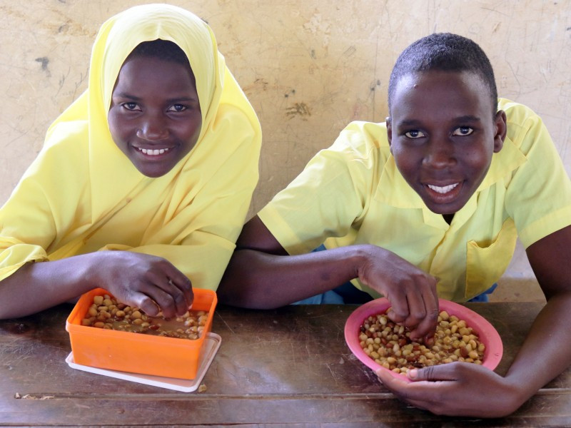 Two young people eating a meal as part of the feeding programme at school
