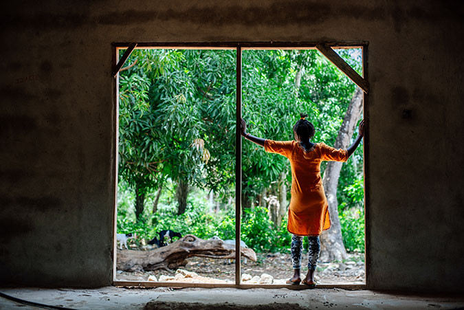 A girls stands in a doorway in Sierra Leone