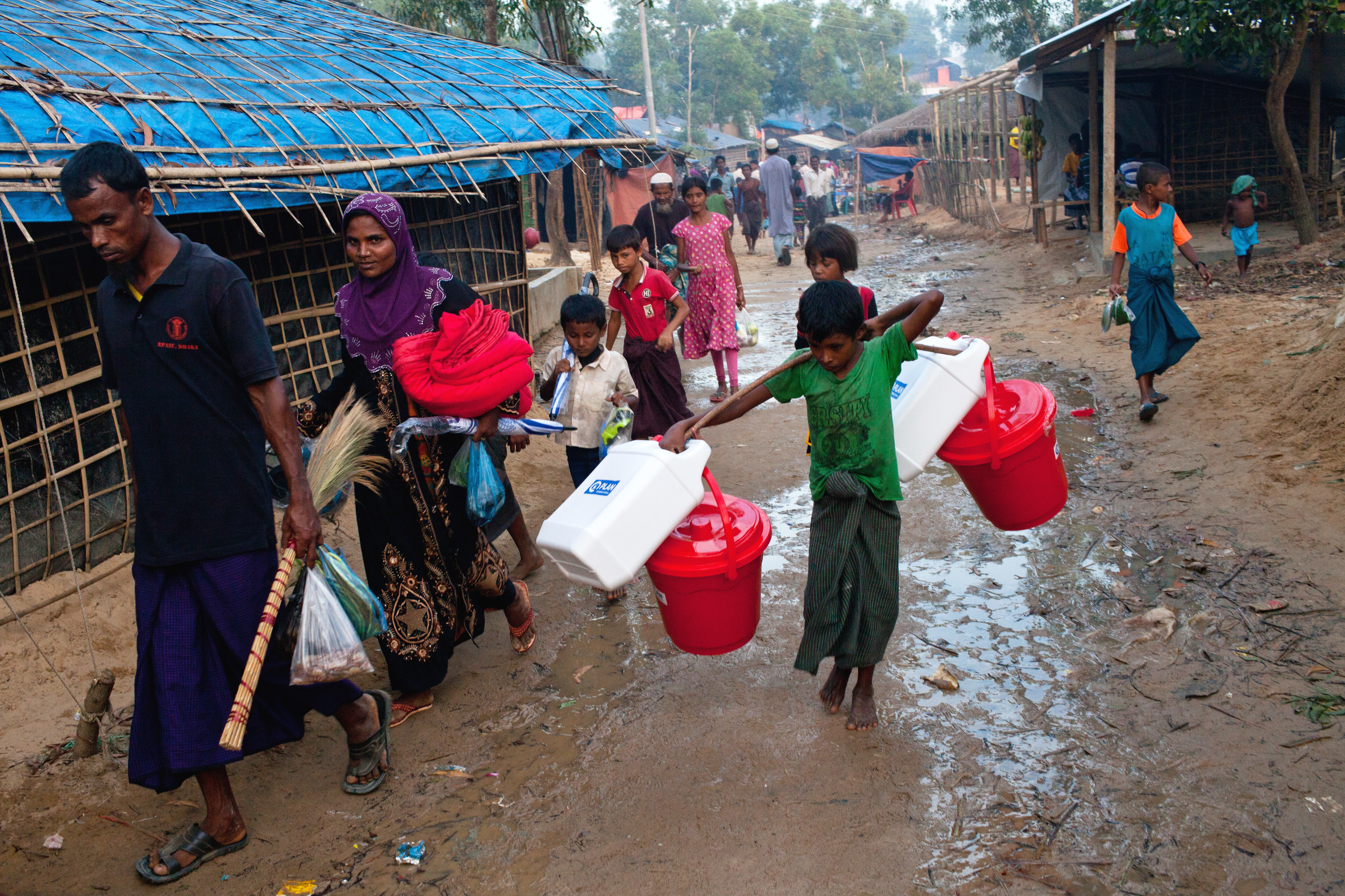 A family carry home their hygiene kit in Cox's Bazar, Bangladesh.