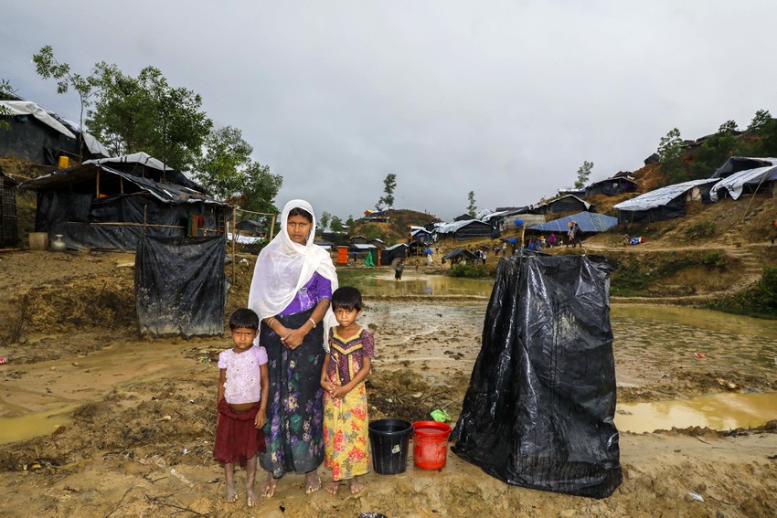 Modina and her two daughters next to a makeshift toilet in their camp in Cox’s Bazar, Bangladesh