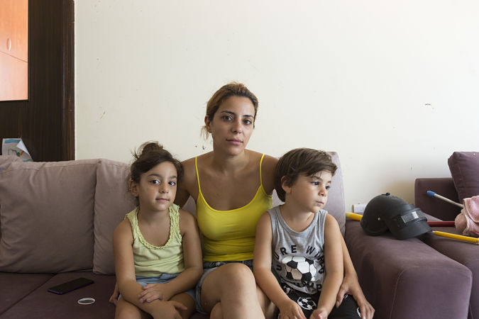 Photo of a woman in a yellow top with two children