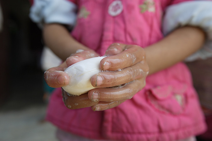 A child washes their hands with soap
