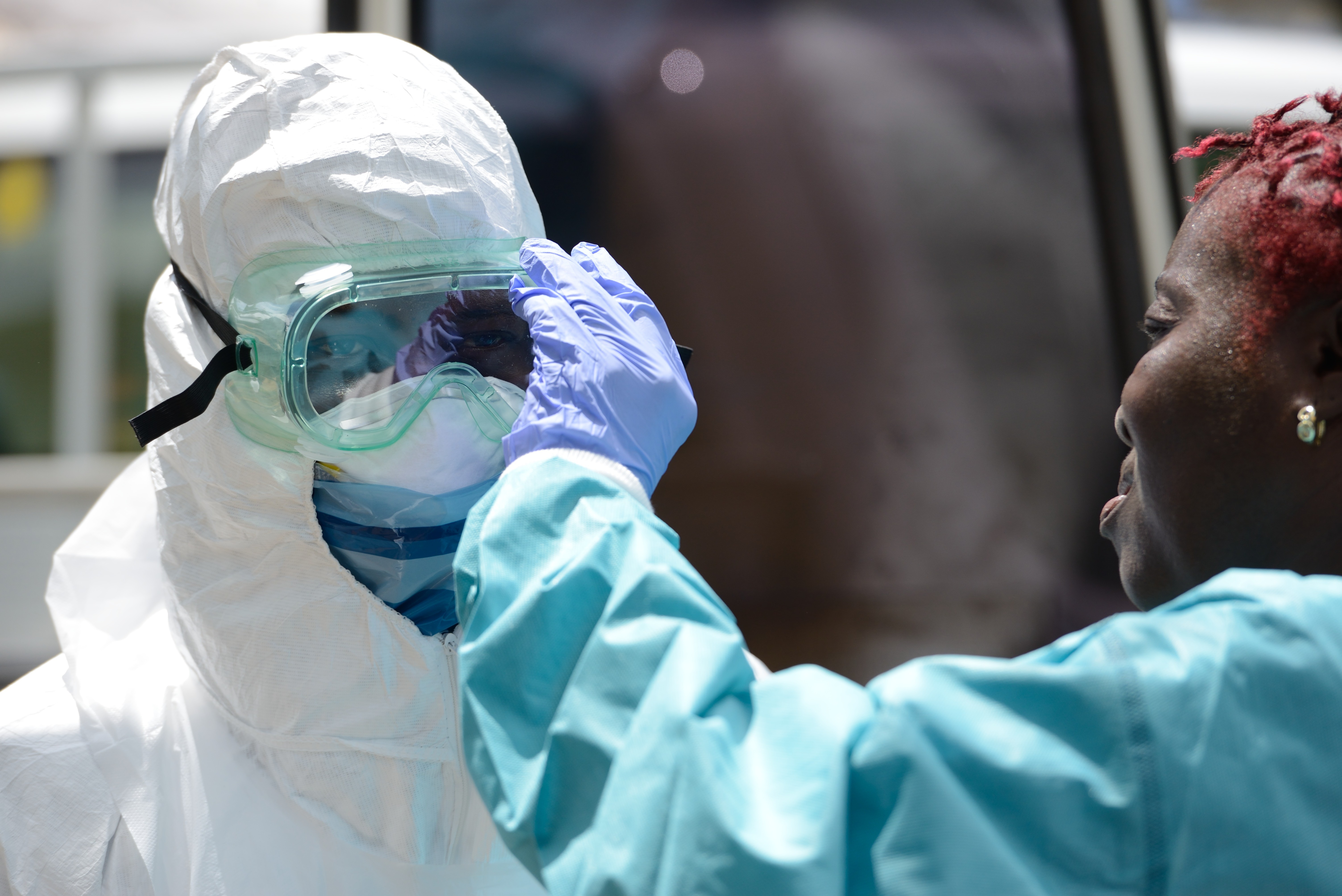 Ebola worker adjusts goggles