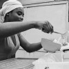 Ghana-Doris prepares an order of Burkina - she adds milk to millet and sugar