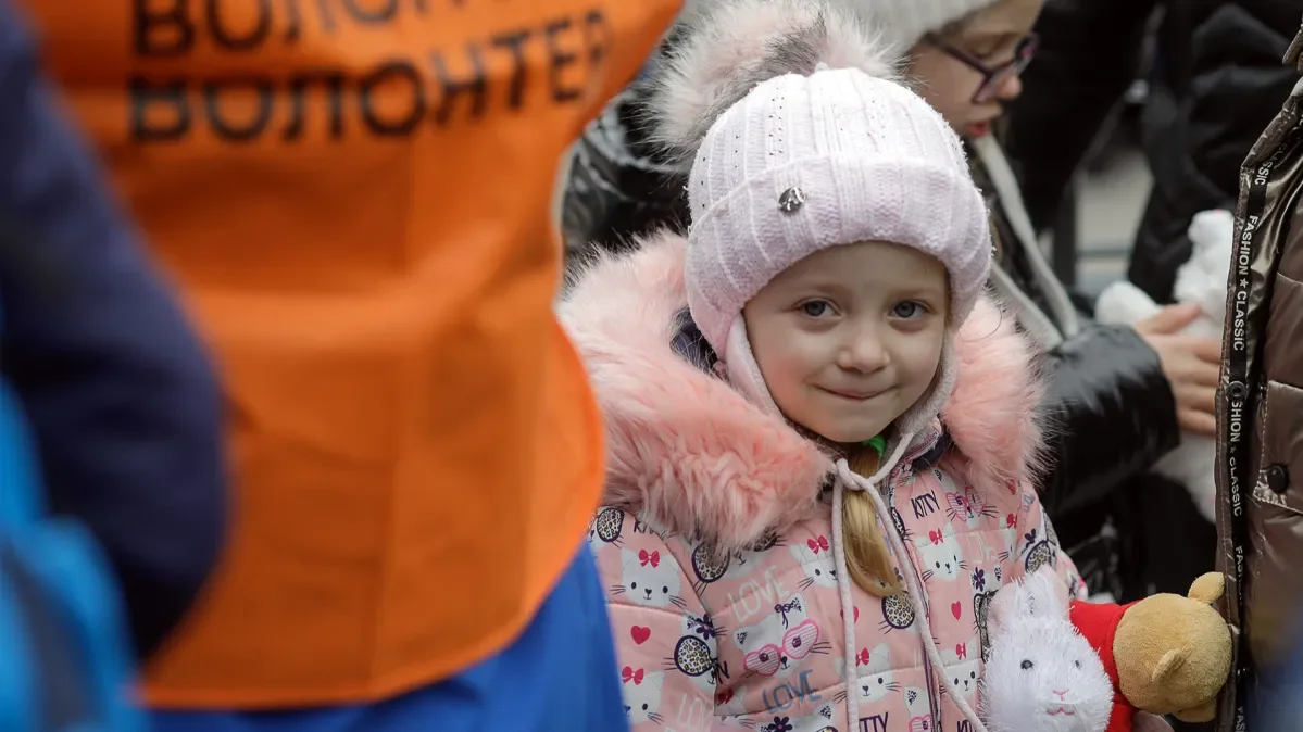 Julia, 5, clutches the toy rabbit she has received after arriving in Isaccea