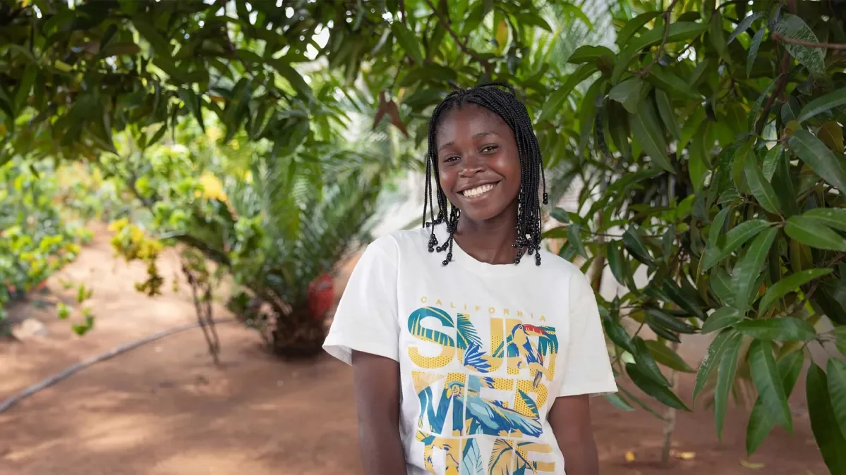 Denise standing by trees smiling