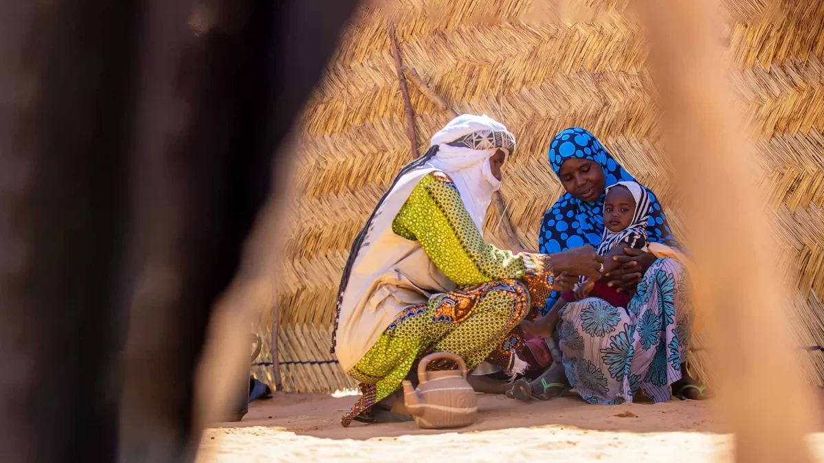 Health worker checks Balkissa's youngest child for malnutrition 