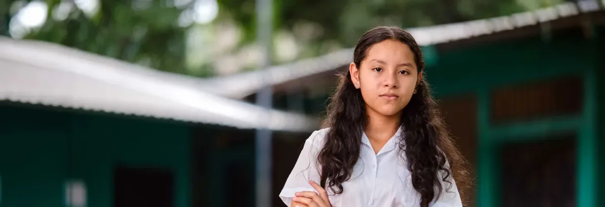 Génesis, standing with arms crossed looking at camera. 