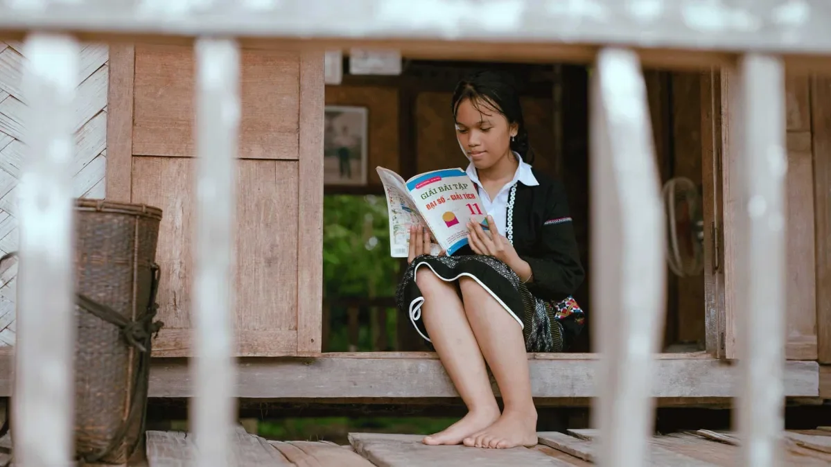 Thach sitting down reading a book.
