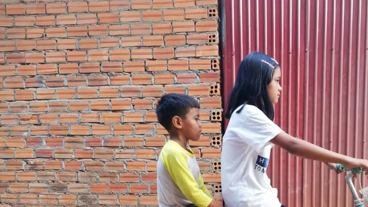 Two children riding a bicycle in Cambodia