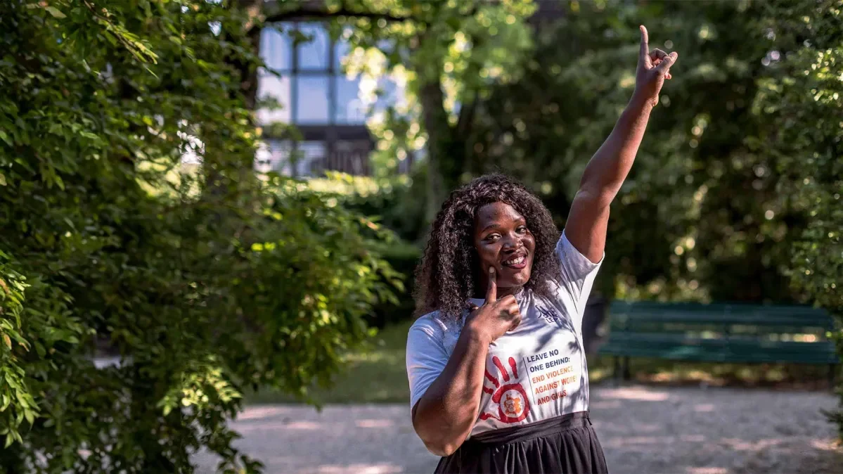 Racheal, 26, pointing her finger to the sky and smiling at the camera