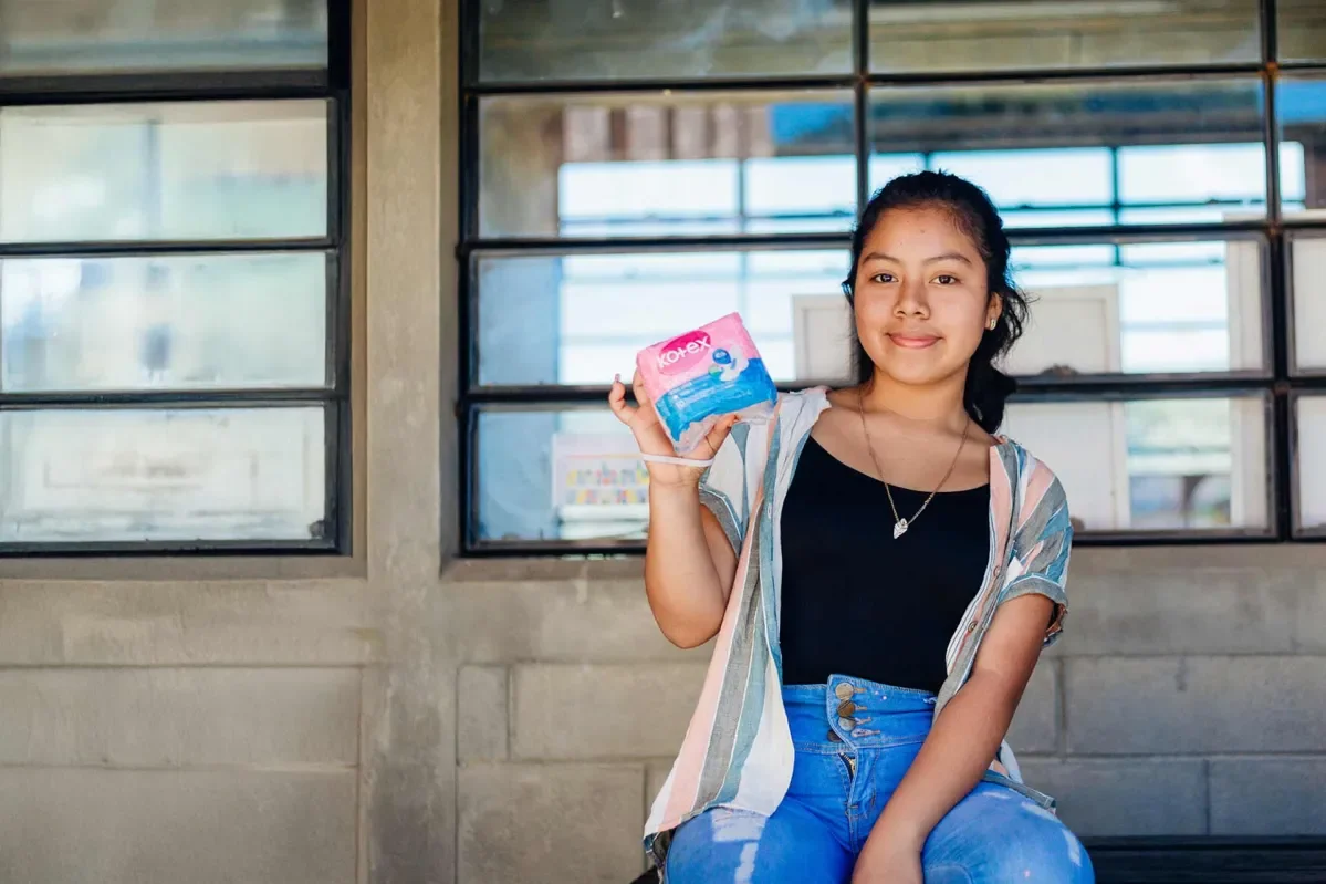 Dalila, 15, holding a dignity kit distributed by Plan International